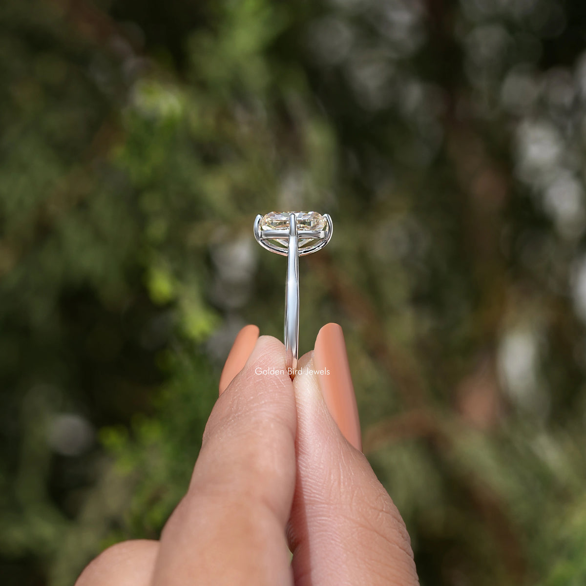 Side view of rose-gold tone solitaire engagement ring with elongated cushion-cut stone