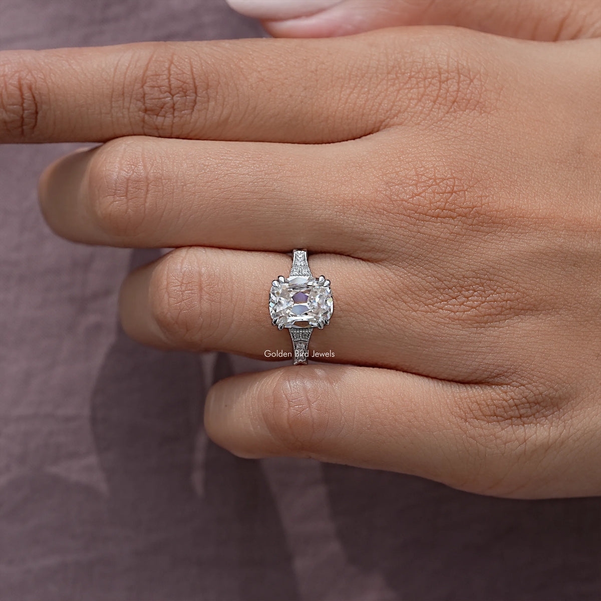 Vintage elongated cushion solitaire ring with halo on hand