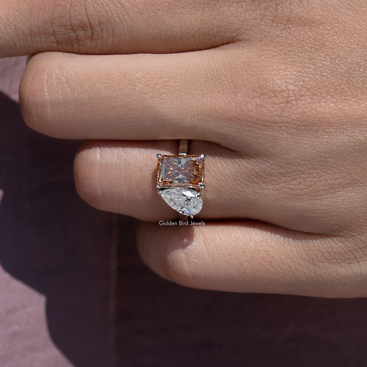 Toi et moi ring on finger, square warm brown and clear moissanite stones with halo accents