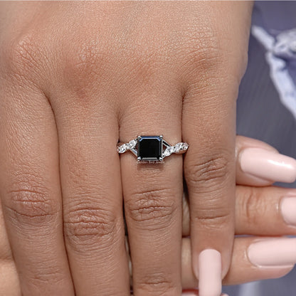 Asscher-cut black center ring on finger with halo stones flanked by round accents