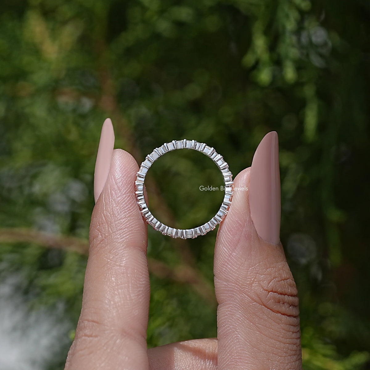 Silver eternity wedding band with round moissanite stones, arched side profile
