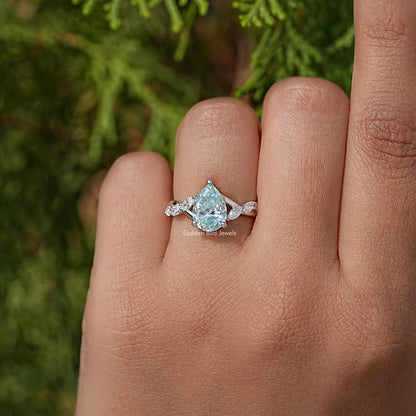 925 sterling silver ring with pear-cut blue moissanite and floral side stones