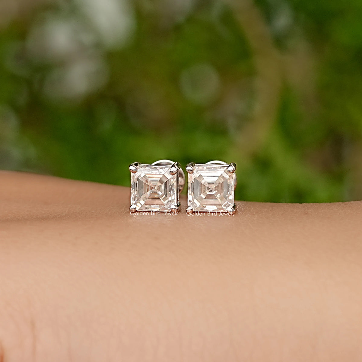 Asscher-cut moissanite stud earrings, square stone settings on white gold posts.