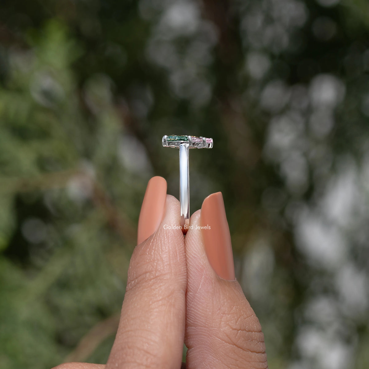 Three-stone engagement ring side view with rectangular prong-set top stone
