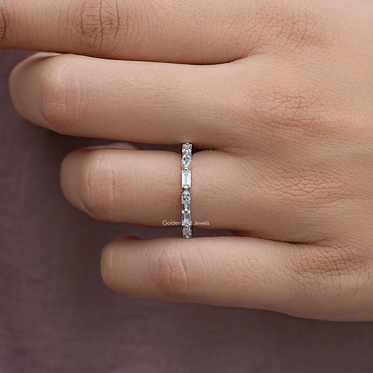 Silver eternity band with marquise stones, close-up side profile on finger