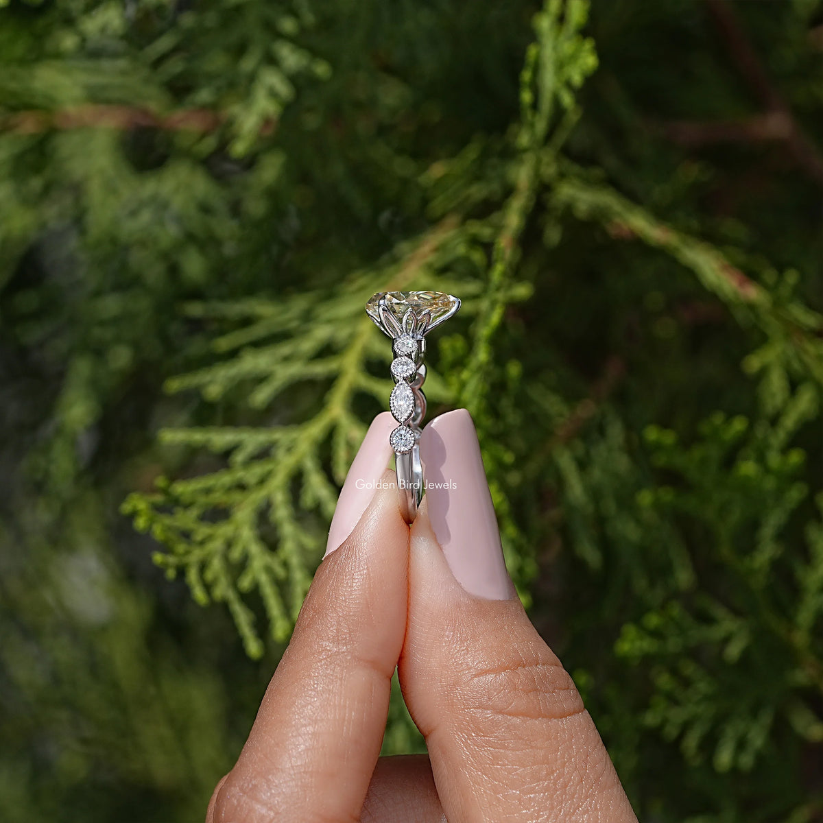 Sterling silver ring showing yellow pear-cut moissanite center and sparkle accents