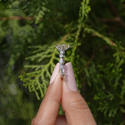 Sterling silver ring showing yellow pear-cut moissanite center and sparkle accents