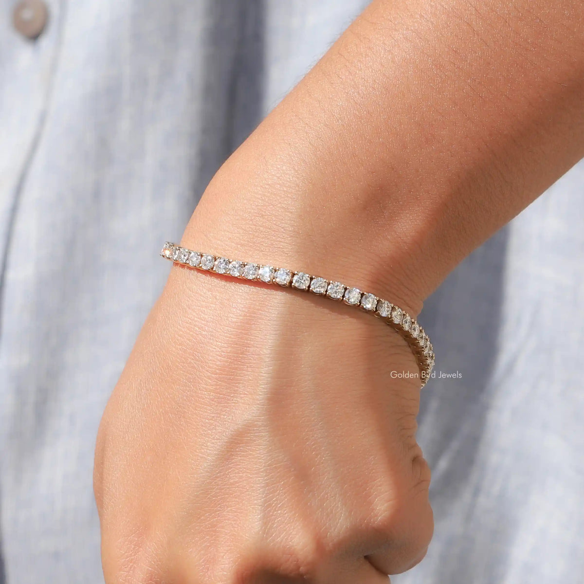 Moissanite tennis bracelet with round-cut sparkle stones, gold-tone, on wrist