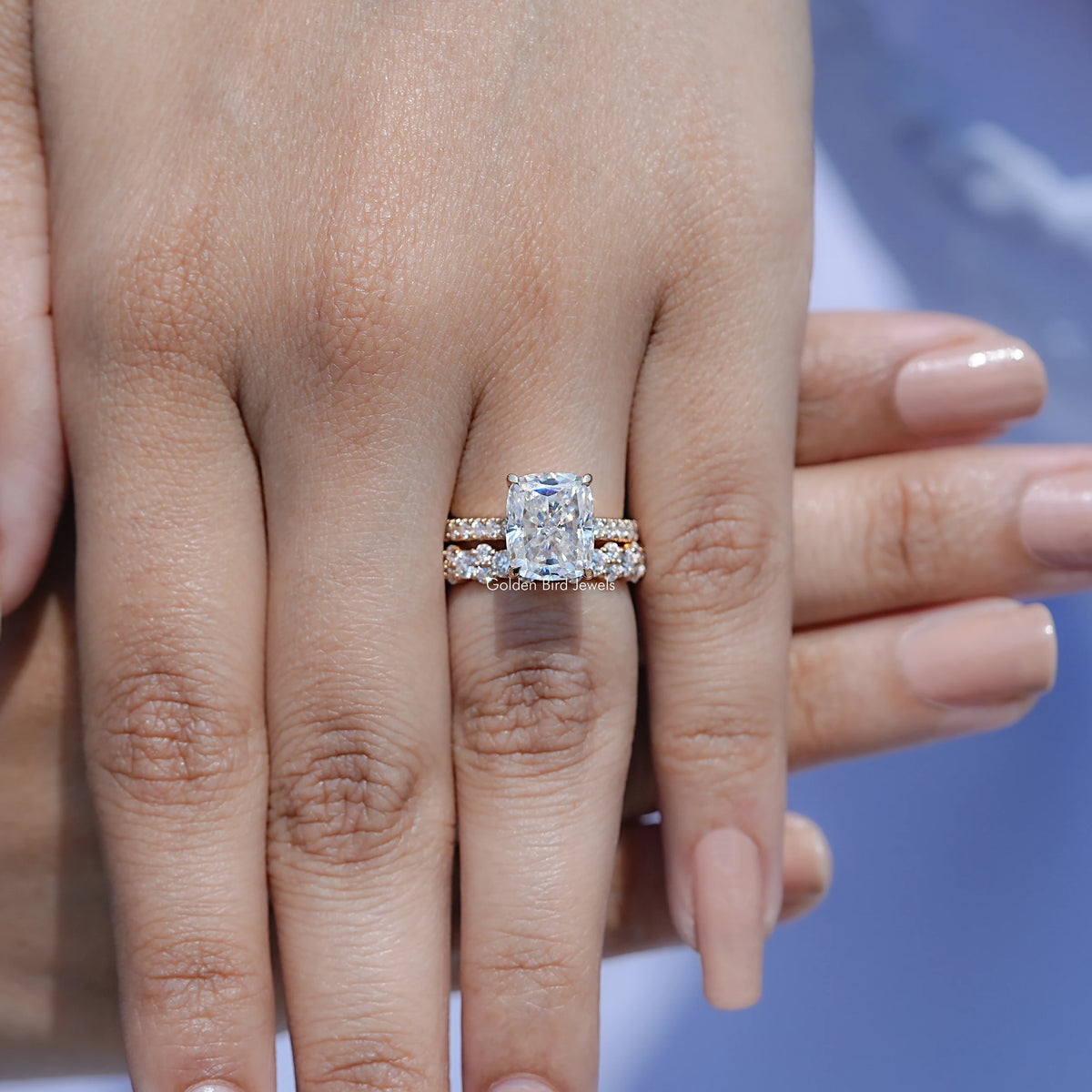 Elongated cushion moissanite ring set close-up on finger with square halo design