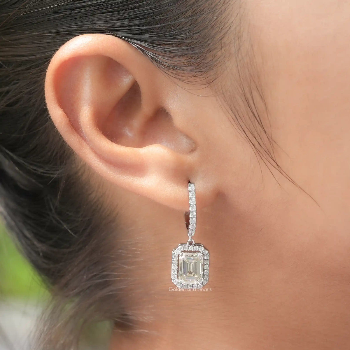 Silver emerald-cut halo drop earrings with vertical dangling design