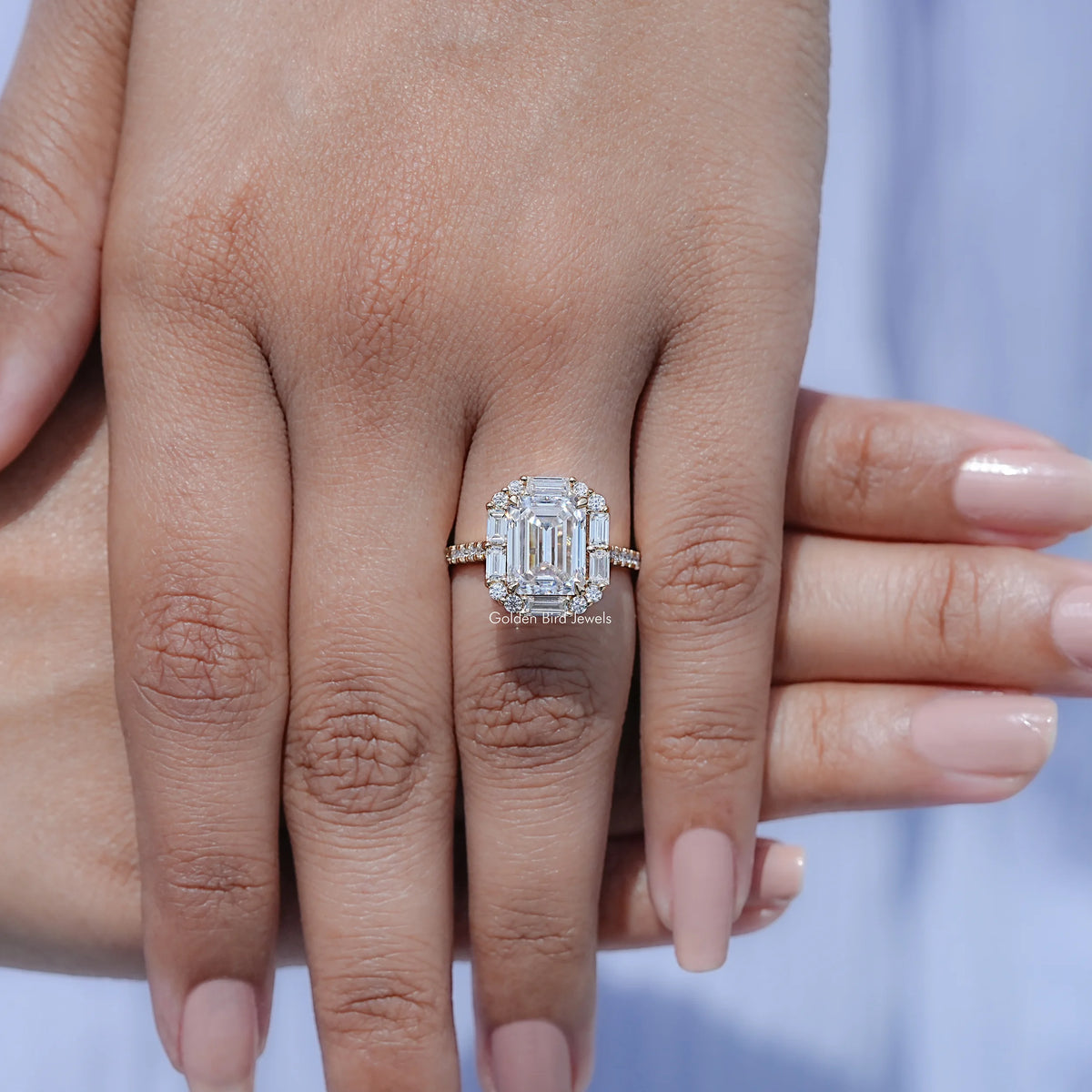 Emerald-cut halo moissanite engagement ring on hand with wide split band