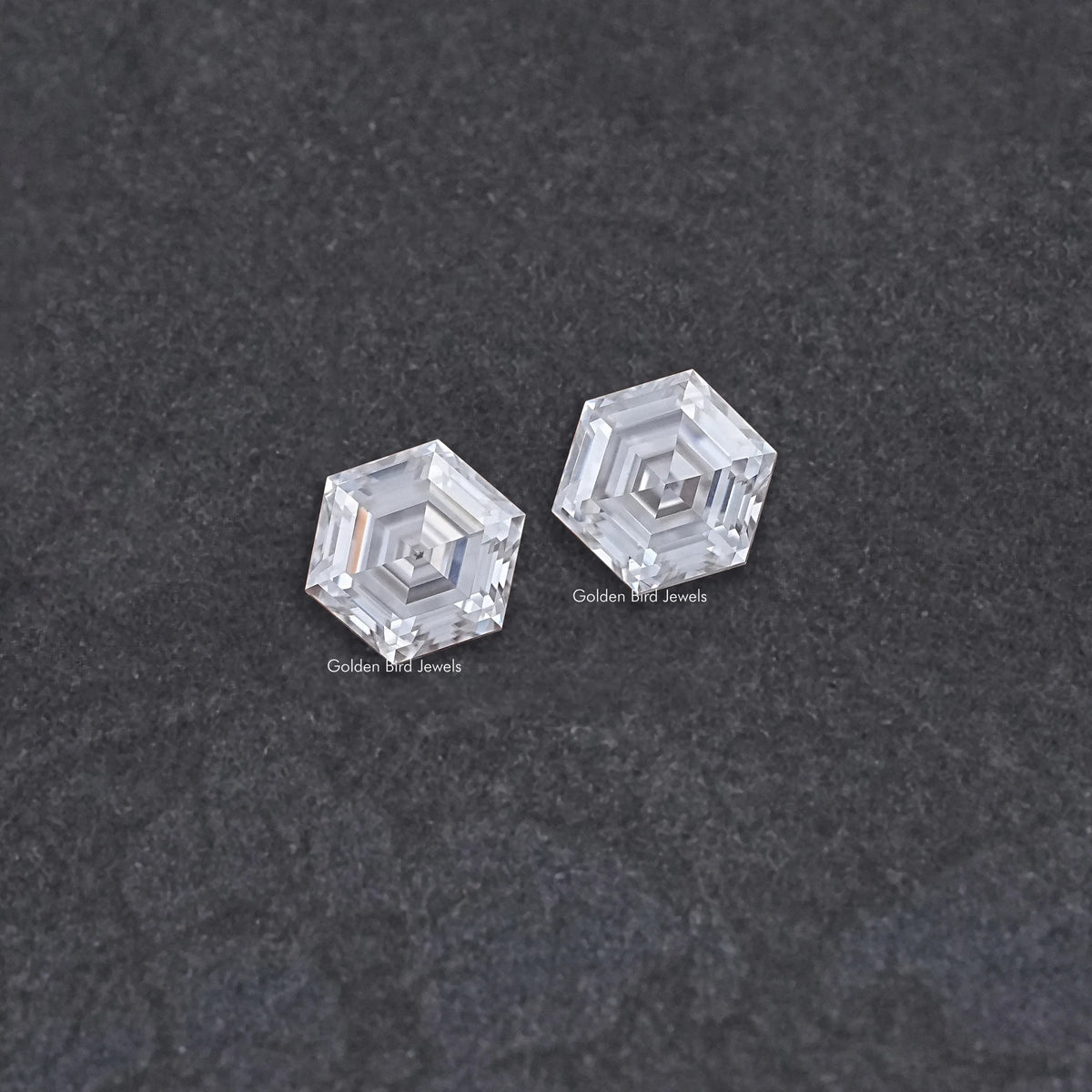 Loose pair of hexagon-cut moissanite stones, clear with faceted surfaces
