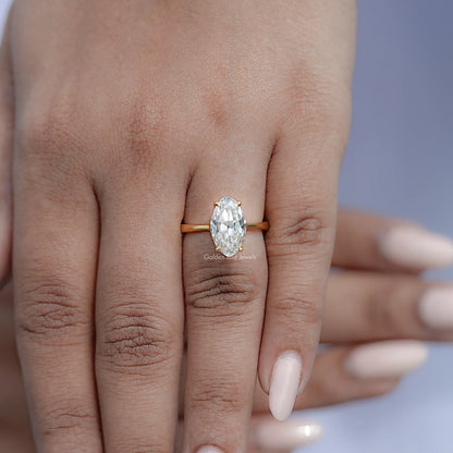 Gold oval moissanite ring with hidden halo, hand model wearing the ring