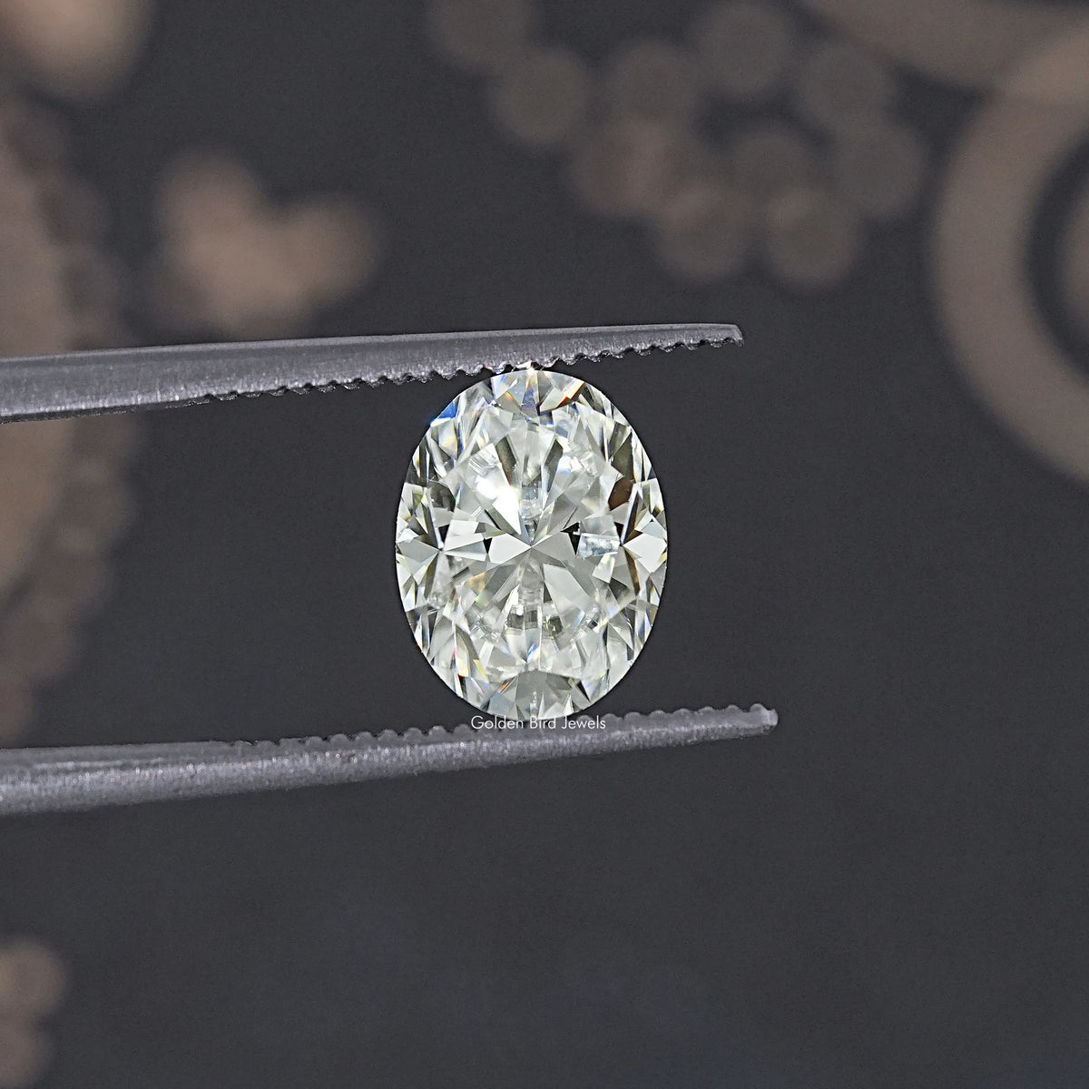 Oval moissanite loose stone, tweezers view showing bright oval facet layout