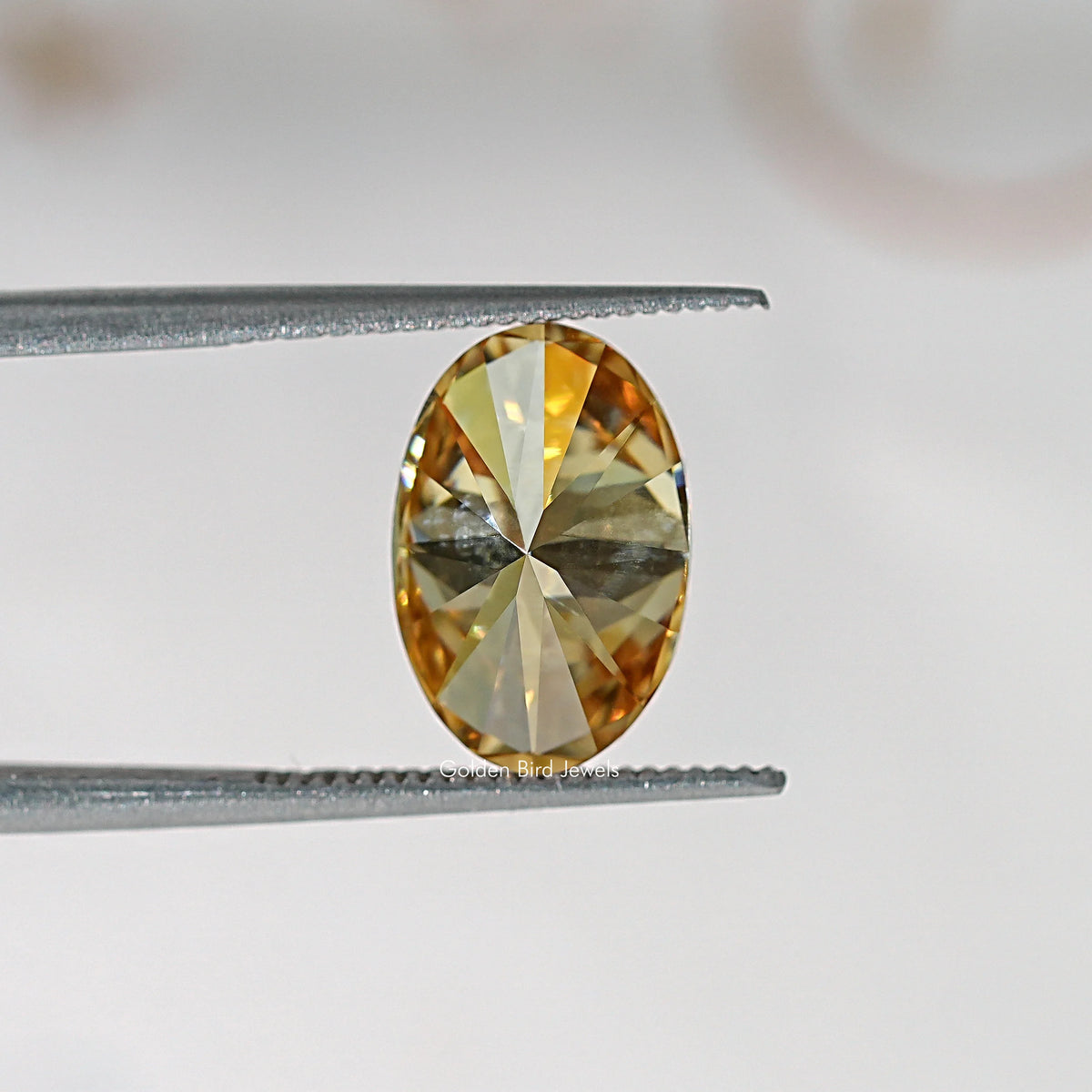 Oval champagne moissanite loose stone close-up with reflective facet pattern
