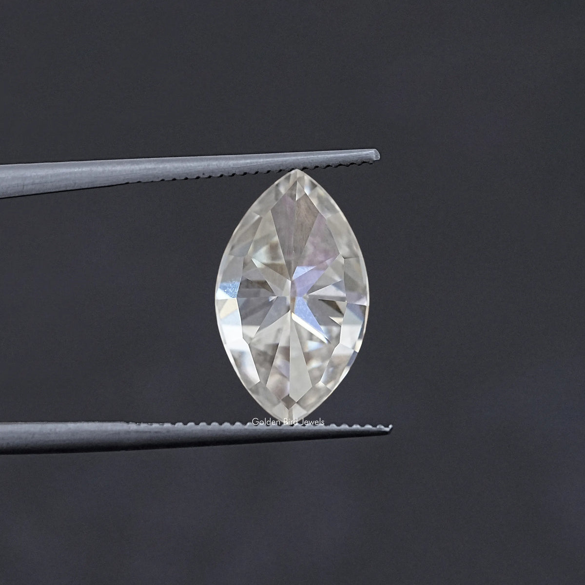 Marquise-cut moissanite stone held in tweezers, faceted clear white