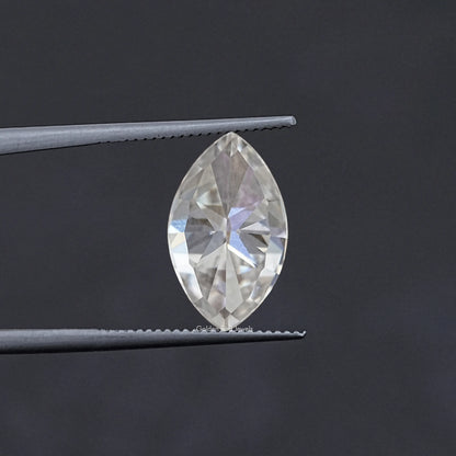 Marquise-cut moissanite stone held in tweezers, faceted clear white
