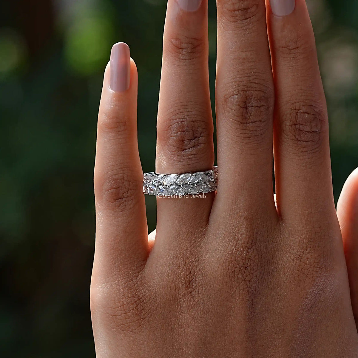 Silver-tone marquise-cut moissanite wedding band on finger, side view