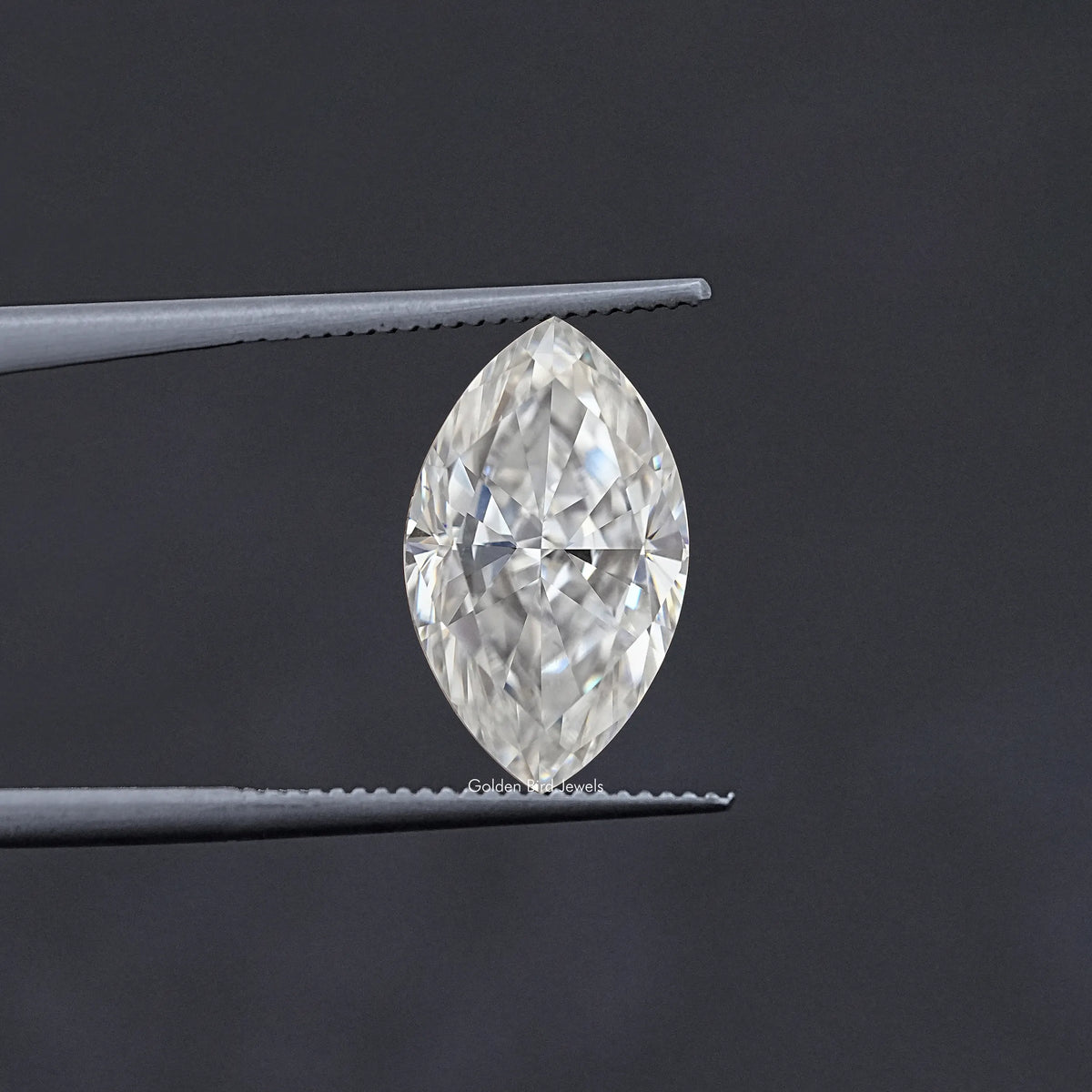 Marquise-cut moissanite stone in tweezers, faceted clear white sparkle