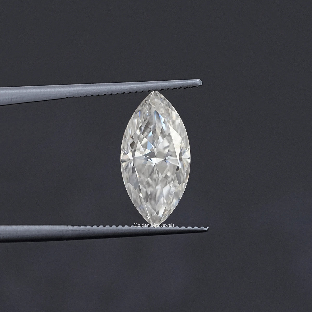 Marquise-cut moissanite loose stone held between metal tweezers, clear white