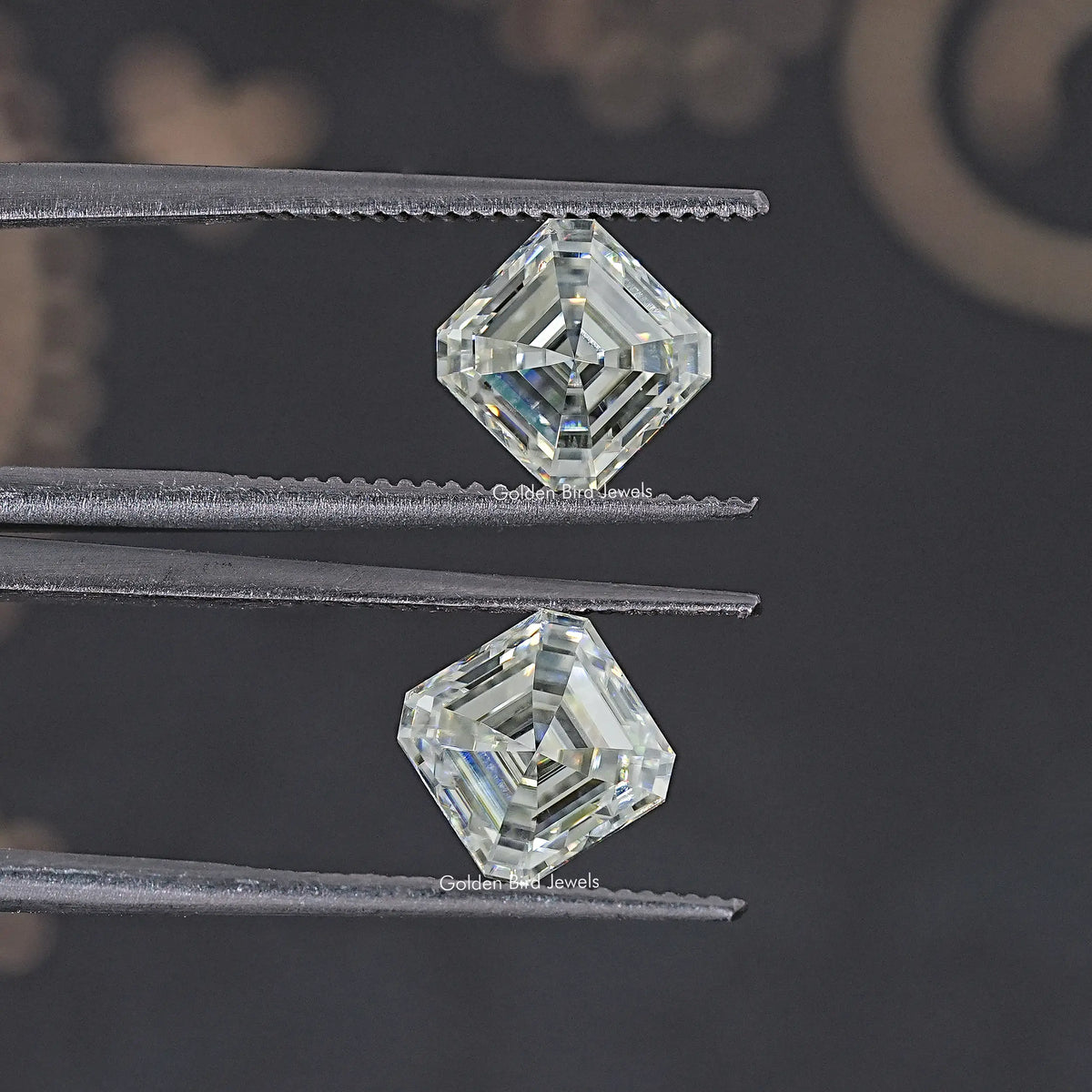 Two clear Asscher-cut moissanite stones shown from above, matching pair