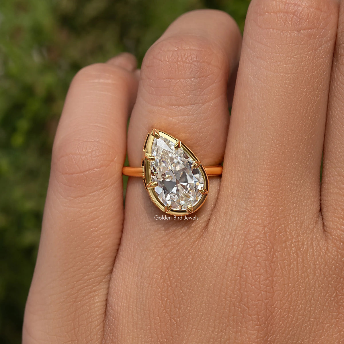 Gold-tone pear-cut solitaire engagement ring with prong-set center stone