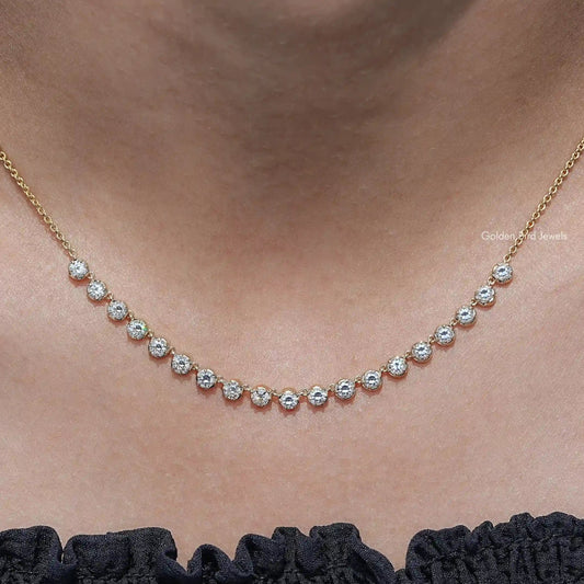 Gold-tone tennis necklace with small round-cut moissanite stones in a line