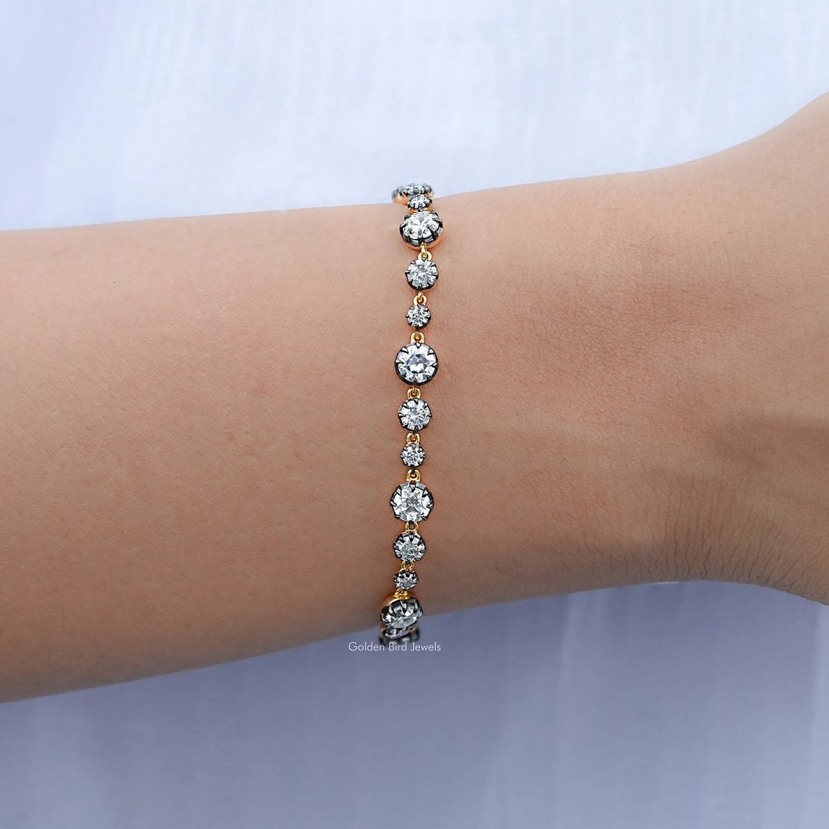 Round-stone tennis bracelet with bright silver setting, worn on wrist