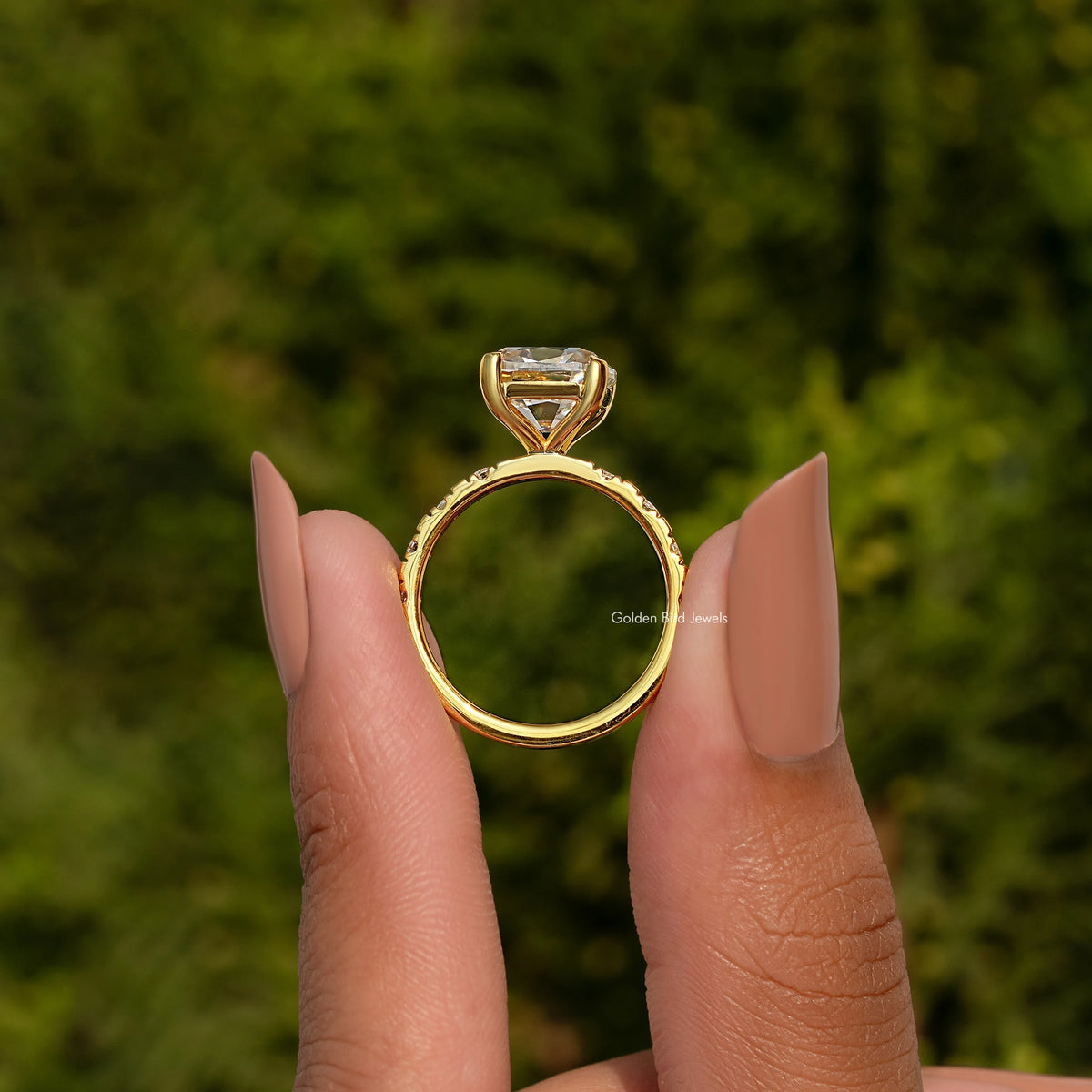 Gold-tone ring viewed from behind, cushion-cut center stone with raised halo setting