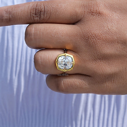 Gold-tone milgrain cushion moissanite engagement ring on hand, side profile of band