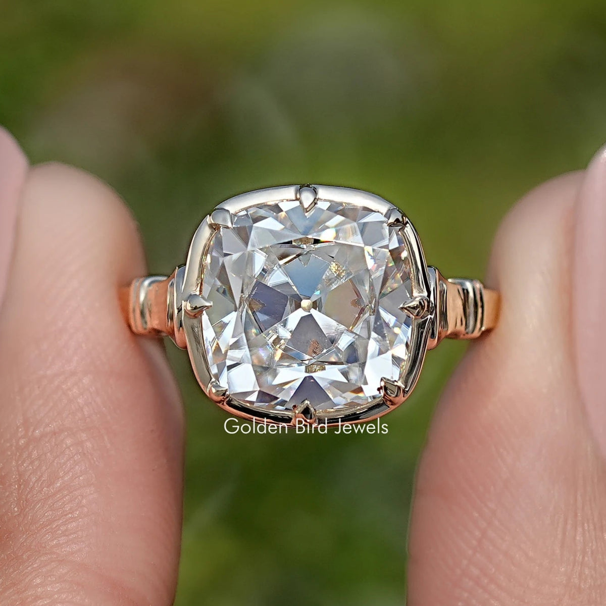 Close-up of gold cushion-cut moissanite solitaire ring with prongs
