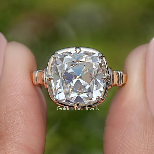 Close-up of gold cushion-cut moissanite solitaire ring with prongs