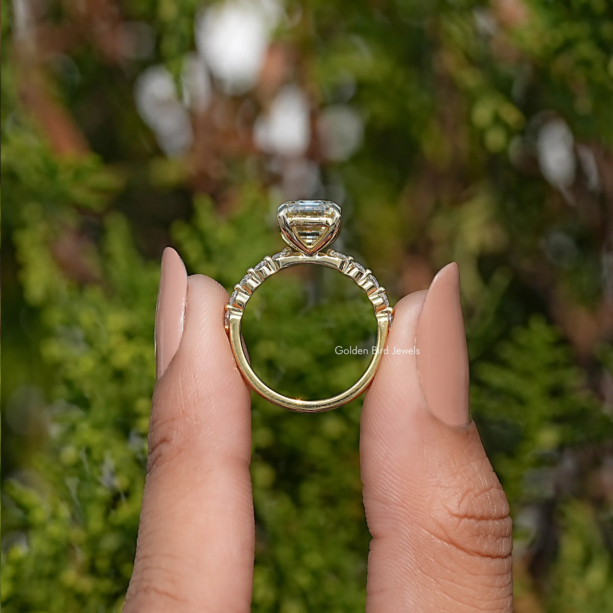 Back view of silver ring with prong-set emerald-cut center stone and slim band
