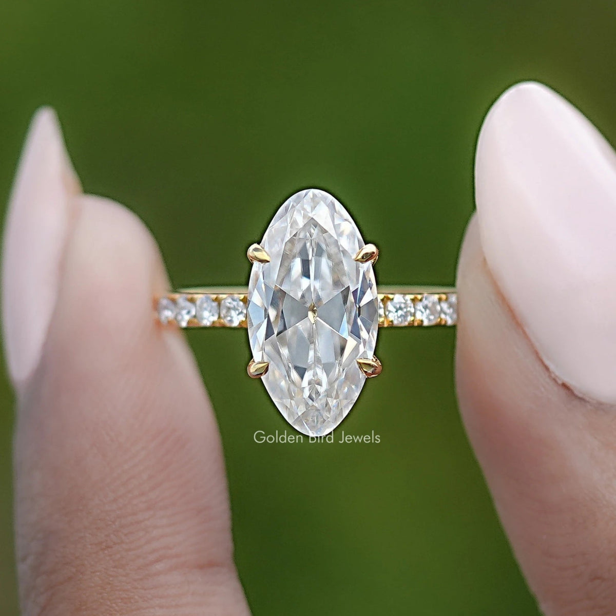 Gold-tone moissanite engagement ring close-up with oval center stone and bar accents