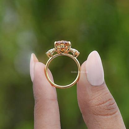 Moissanite engagement ring side view with oval top setting and prongs, gold tone
