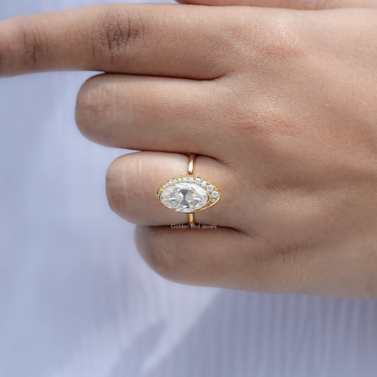 Gold halo engagement ring with oval moissanite center stone and slim band