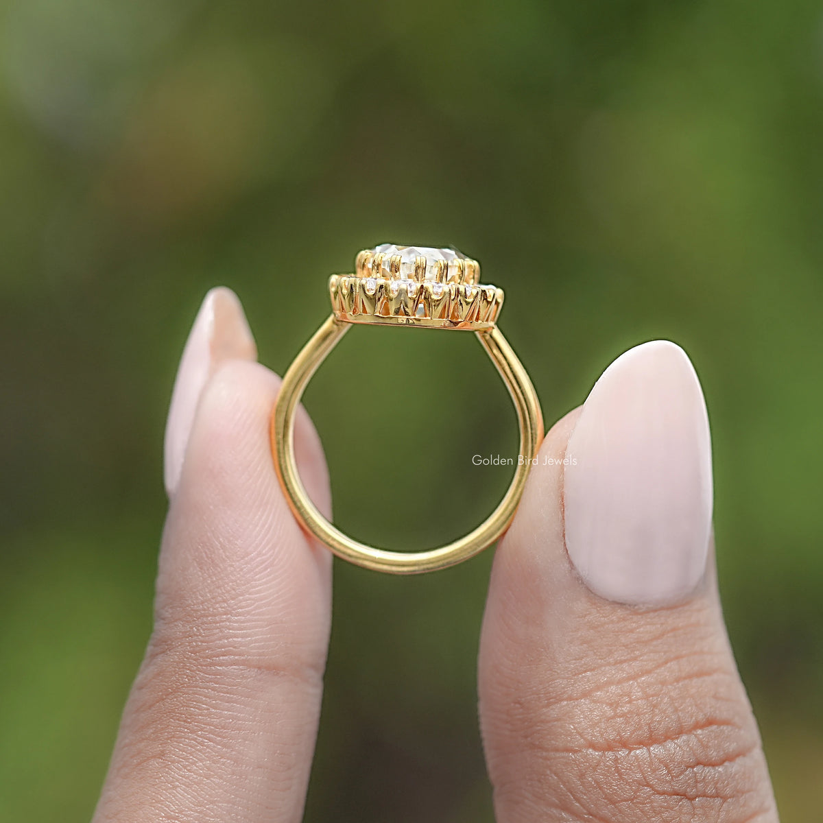 Gold-tone oval halo engagement ring side view, prong-set crown