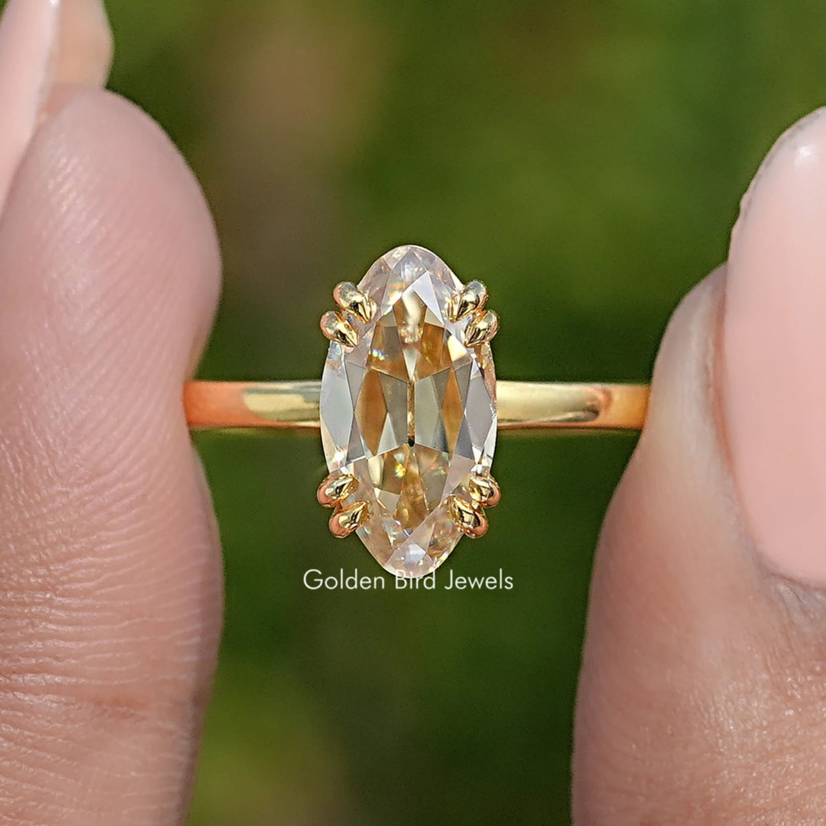 Yellow gold solitaire ring featuring an oval center stone with four decorative prongs