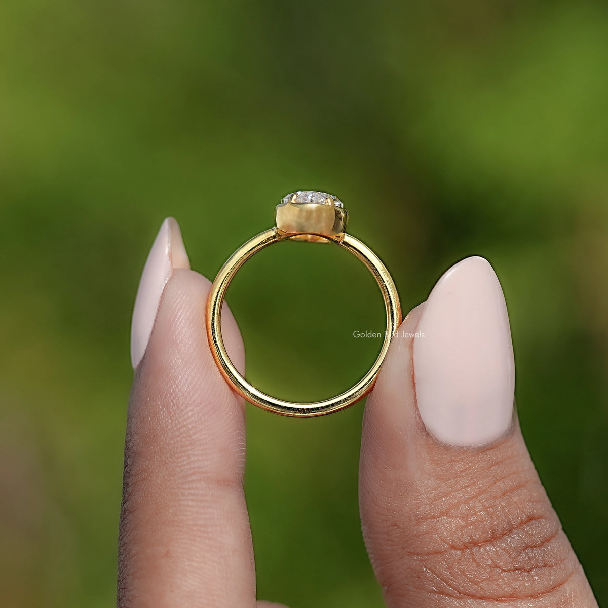 Oval bezel-set moissanite ring with gold band