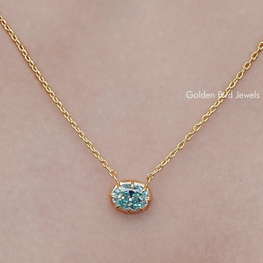 Oval moissanite solitaire pendant necklace with gold-tone chain and blue gemstone