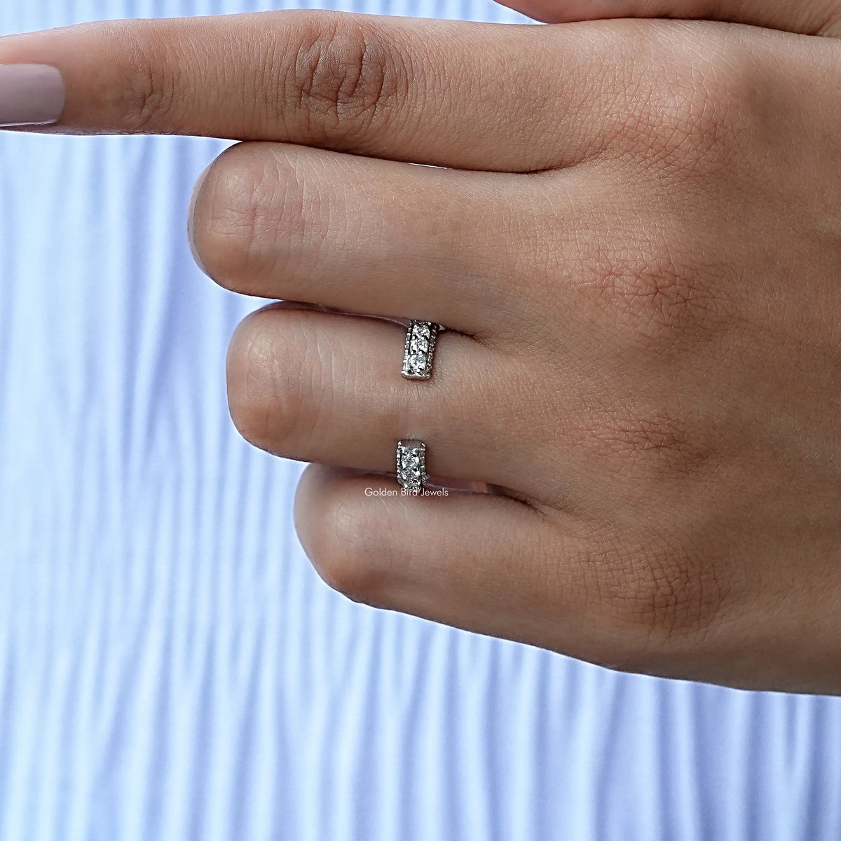 Open moissanite eternity band ring with round stones, silver-tone, on finger close-up