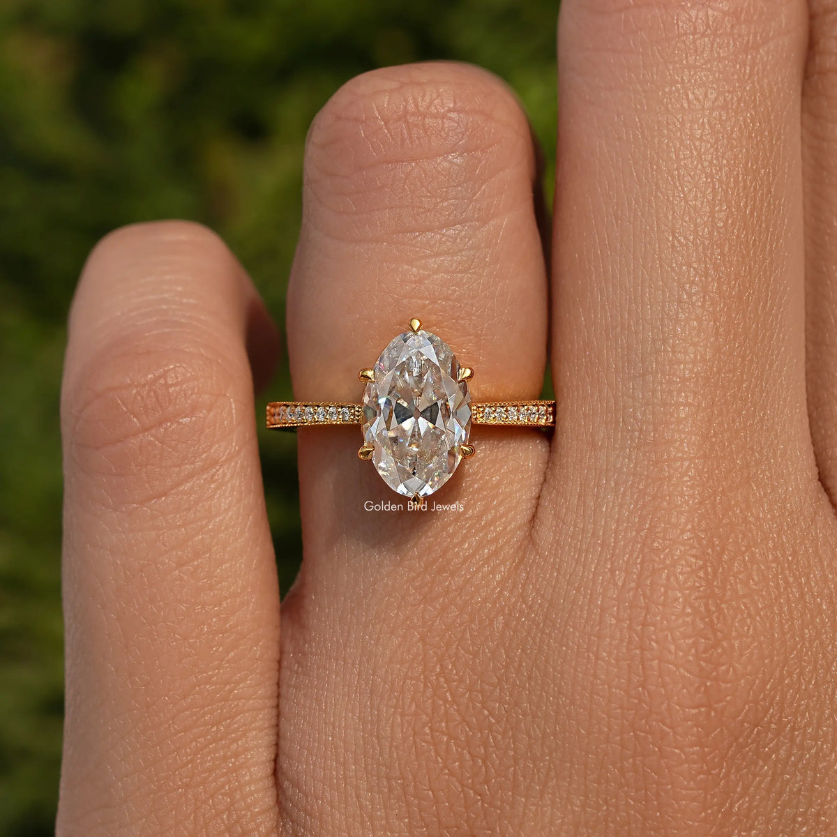 Oval moissanite accent stone ring in 925 sterling silver, shown on a finger.