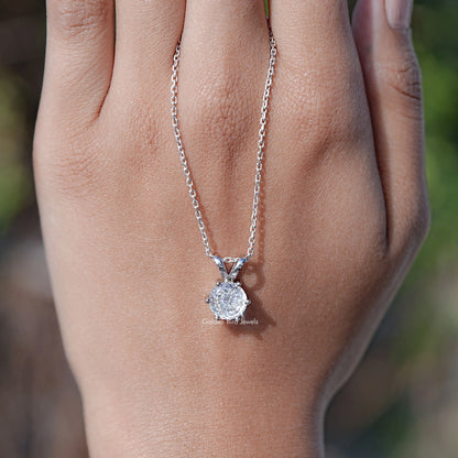 Silver round moissanite pendant necklace on chain, centered over palm view