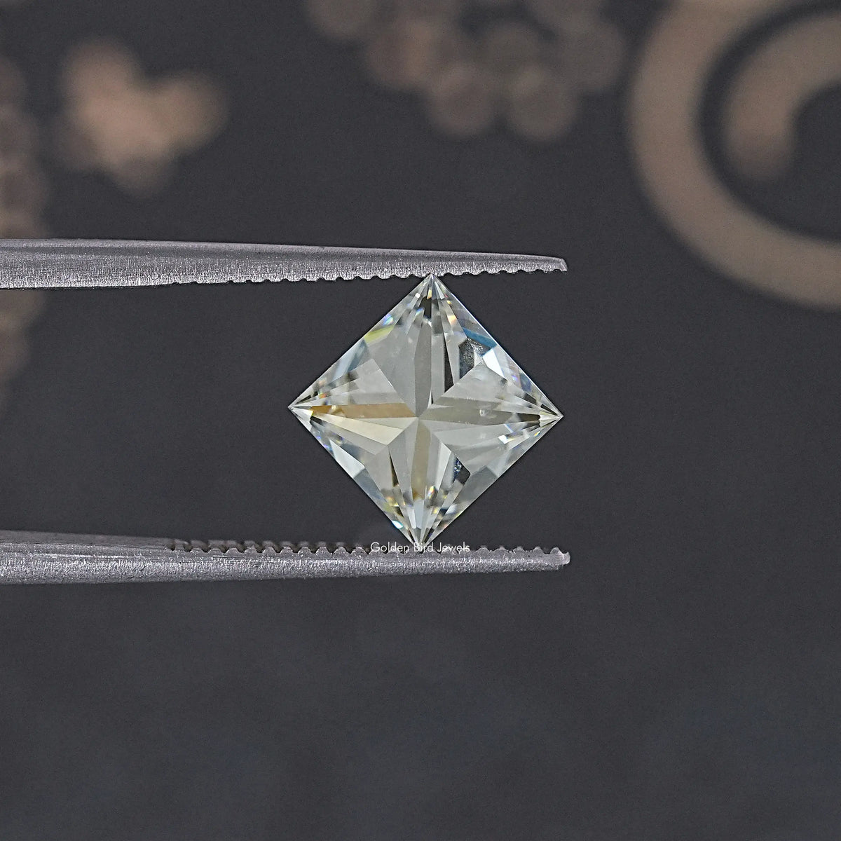 Princess-cut moissanite loose stone, centered on tweezers tips; diamond-tilted sparkle.