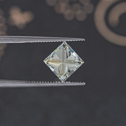 Princess-cut moissanite loose stone, centered on tweezers tips; diamond-tilted sparkle.