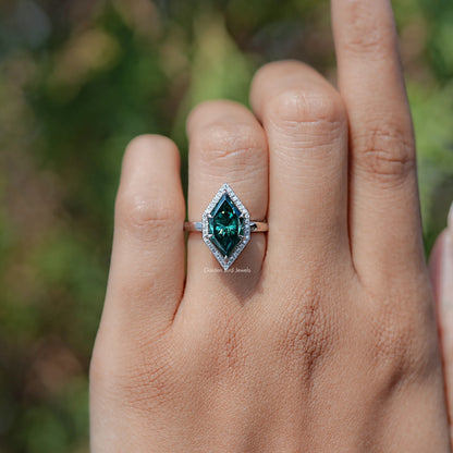 Teal marquise halo engagement ring with rectangular center stone, side view on hand