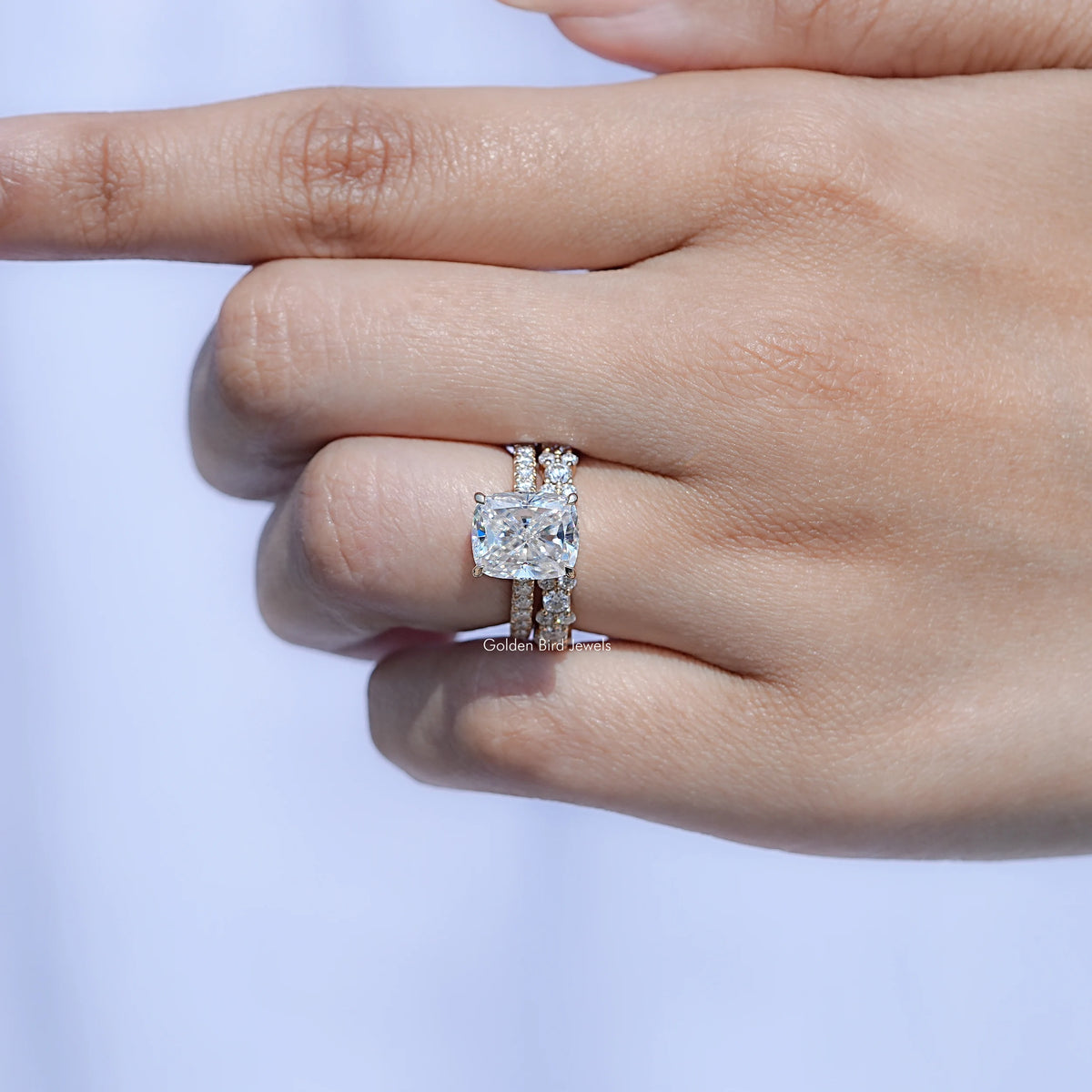 Elongated cushion moissanite ring set on hand, cushion-cut center with halo