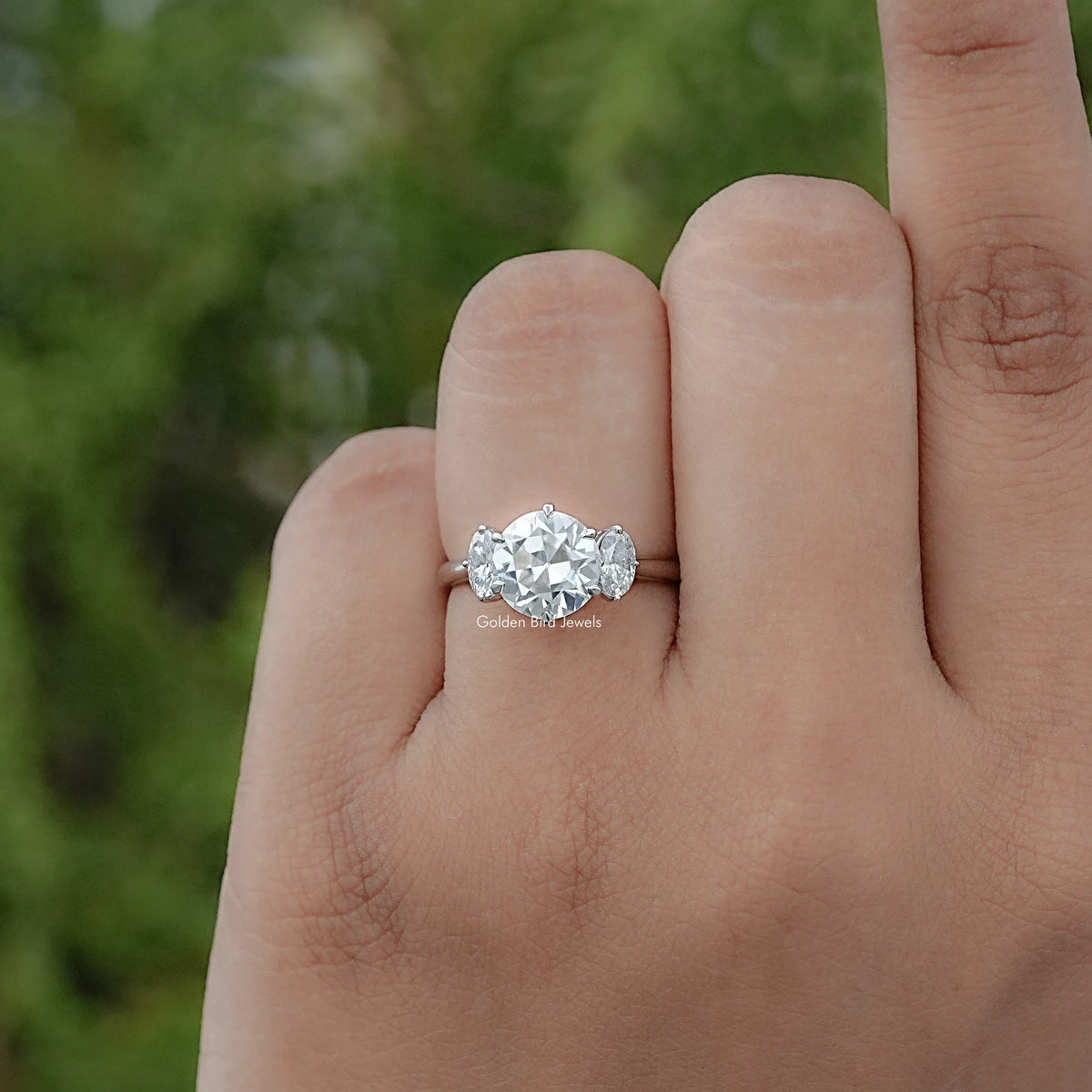 In finger view of Round And Oval Cut Moissanite Engagement Ring 