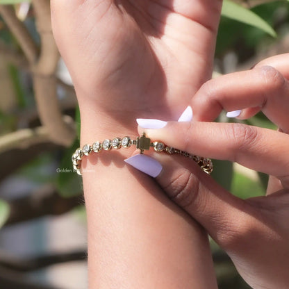 Round-stone moissanite bezel bracelet being fastened on wrist