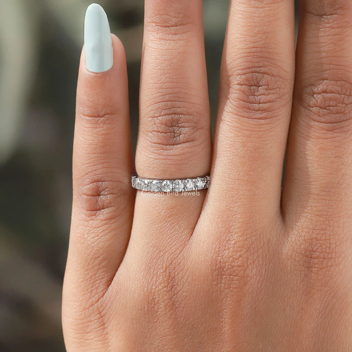 Sterling silver moissanite eternity stacking band on finger with prong-set round stones